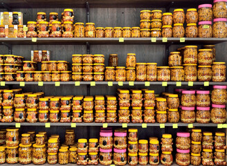 Sale of honey in a specialized store: honey is in jars of different shapes with the addition of nuts and dried films
