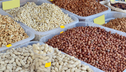 pistachios, almonds, cashews, hazelnuts are in plastic containers for sale