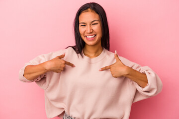 Young latin woman isolated on pink background  surprised pointing with finger, smiling broadly.