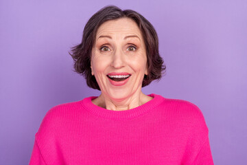 Photo of senior woman amazed shocked surprised happy positive smile sale news isolated over violet color background