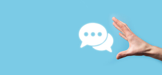 Businessman holding a message icon, bubble talk notification sign in his hands. Chat icon, sms icon, comments icon, speech bubbles