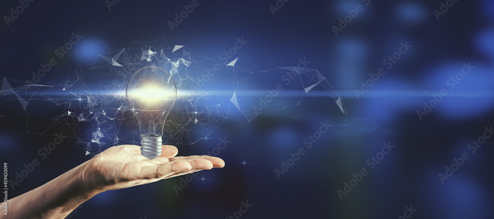 Poster close up of hand holding glowing polygonal lightbulb on blurry blue background with mock up place. i