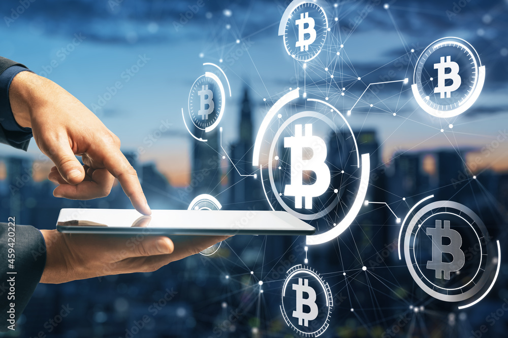 Aufkleber Close up of businessman hand pointing at tablet with abstract glowing bitcoin hologram interface on blurry night city background. Cryptocurrency and blockchain concept. Double exposure.