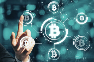 Close up of man hand pointing at abstract glowing bitcoin hologram interface on blurry bokeh background. Cryptocurrency and blockchain concept. Double exposure.