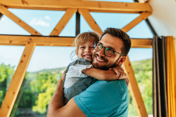 Obraz premium Man hugging shy daughter at home