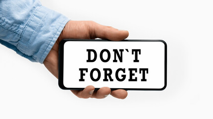 Closeup of a male hand holding Smartphone with horizontal text DonT Forget on display