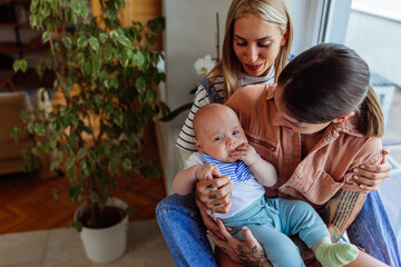 Young loving lesbians with baby at home