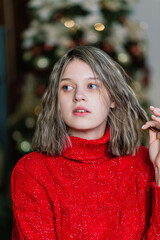 Happy emotional surprised young woman by Christmas tree in cozy living room, concept of happiness