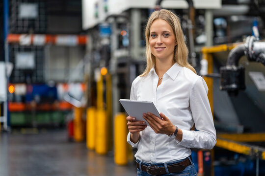 Female professional with digital tablet standing at factory