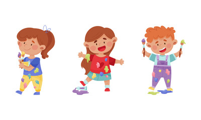 Creative kids in stained clothes holding paint brushes set cartoon vector illustration