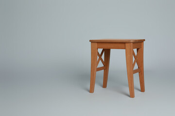 Stylish wooden stool on light grey background. Space for text