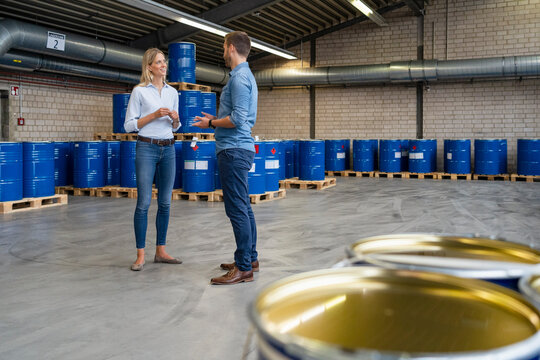 Male and female coworkers having discussion at paint warehouse