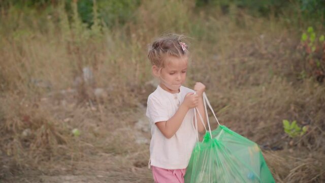 Little girl helps mother collects plastic garbage on nature to save environment from pollution Kid collecting plastic trash waste bottles volunteer teamwork Save the Planet caring about environment. 