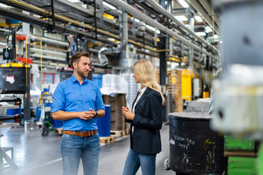 Male And Female Coworkers Having Discussion At Industry