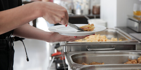 Woman taking food from a buffet line
