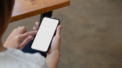 Top view Woman sitting and holding blank screen mock up mobile phone