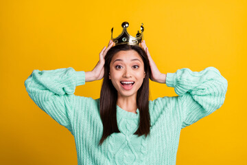 Photo of adorable impressed young lady wear turquoise sweater diadem smiling arms head isolated yellow color background © deagreez