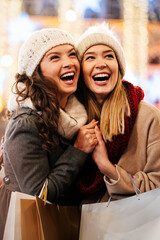 Sale, shopping, tourism and happy people concept. Beautiful females with shopping bags in the city