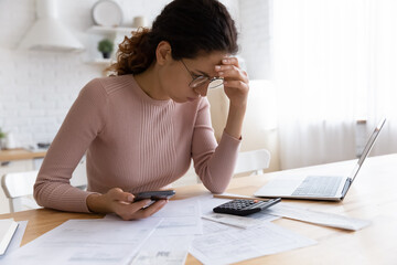 Unhappy millennial female frustrated with financial mistake calculating household expenses paying...