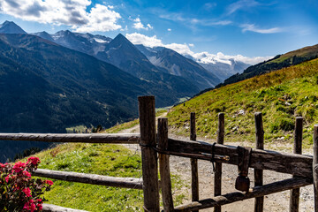 Fototapeta na wymiar Mountain pub fence with bell and view on Alps