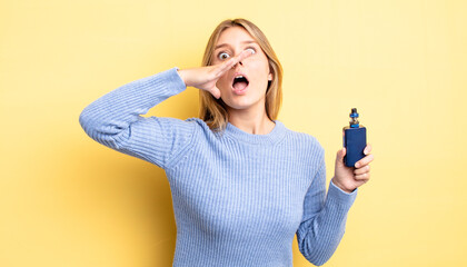 pretty blonde girl feeling happy,giving a big shout out with hands next to mouth. smoke vaporizer...