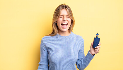 pretty blonde girl shouting aggressively, looking very angry. smoke vaporizer concept