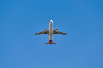 Airbus A320 of the Iberia airline seen with a low angle just after take off in a blue sky