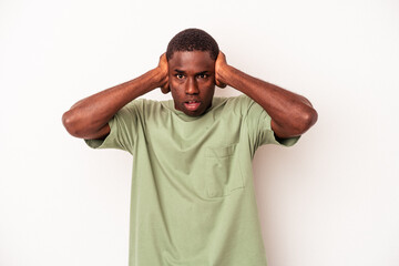 Fototapeta na wymiar Young African American man isolated on white background covering ears with hands trying not to hear too loud sound.