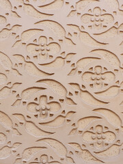 Beige wall ornament outside in Segovia, Spain. Arabic motif, oriental ornate. Vertical photo