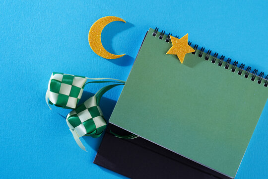 blank desktop caledar with new moon , star and ribbon ketupat time to celebrate ramadan