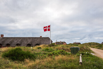 danish flag flying in front of a cottage