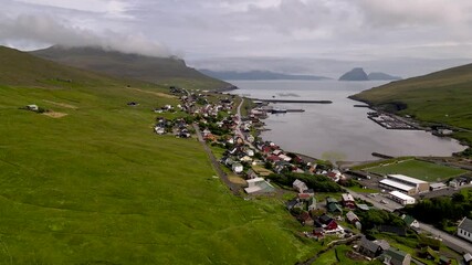 Beautiful aerial view of the town of Miovagur in the Faroe Islands, with its :churchs, grass roofs and colorful Houses in front of the ocean	