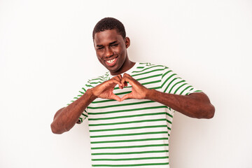 Young African American man isolated on white background smiling and showing a heart shape with hands.