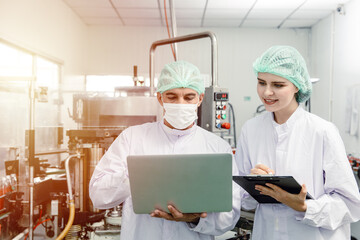 Factory staff worker check quality control in factory or industry research team collect data in beverage factory with laptop.