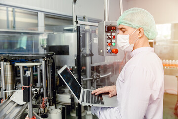 engineer working with laptop in food factory machine production inspector with hygiene clothes.