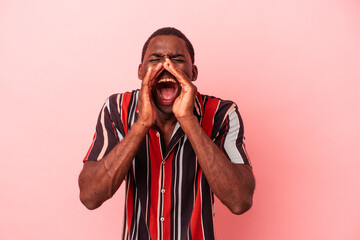 Young African American man isolated on pink background shouting excited to front.