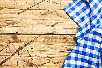 Blue white checkered kitchen towel on old wooden background. Advertising, kitchen, cooking, eating template, frame or banner, top view, copy space
