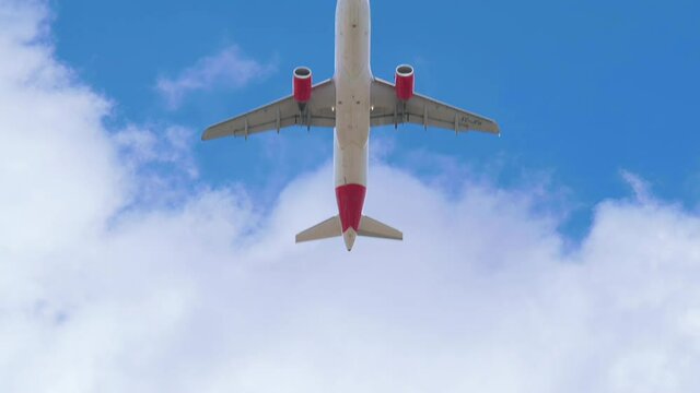 4k Slow motion of an Airbus A320 of the Iberia airline seen with a low angle just after take off in a blue sky