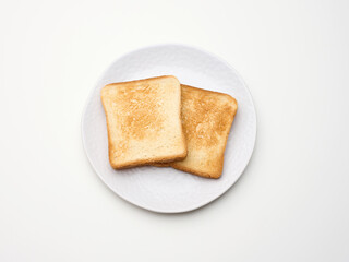 square pieces of toasted bread made from white wheat flour on a round plate. White table background
