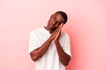 Young African American man isolated on pink background yawning showing a tired gesture covering mouth with hand.