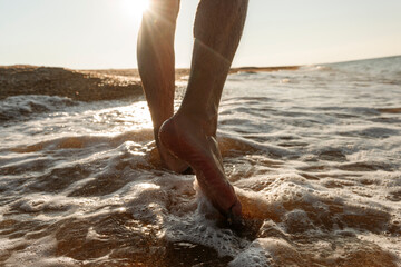Man walking in water on shore at beach