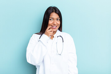 Young doctor Venezuelan woman isolated on blue background relaxed thinking about something looking at a copy space.