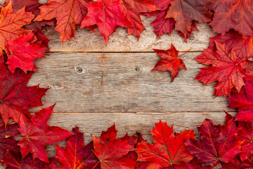 Wooden background with red autumn maple  leaves