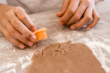 Preparing to celebrate halloween and preparing a treat. Children cut out from rolled dough to bake...