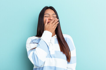 Young Venezuelan woman isolated on blue background laughing happy, carefree, natural emotion.