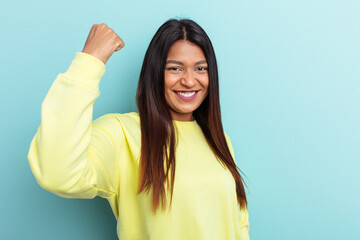 Young Venezuelan woman isolated on blue background cheering carefree and excited. Victory concept.