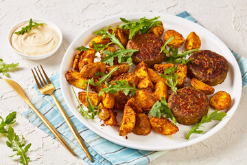 vegan lentil patties with baked potato and hummus