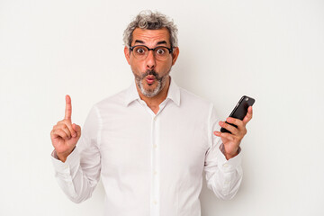 Middle age caucasian business man holding a mobile phone isolated on white background  having some great idea, concept of creativity.