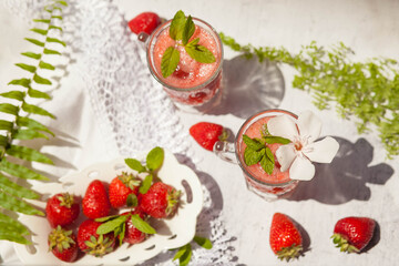 Refreshing summer drink with strawberry on light background