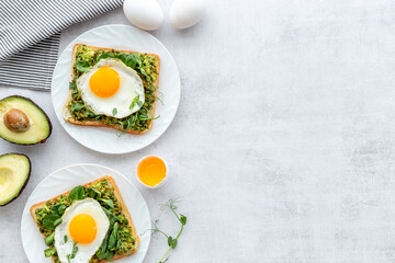 Toasts with avocado and fried eggs. Healthy breakfast